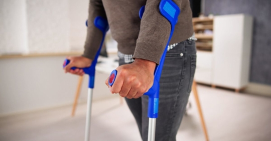 man using crutches at work